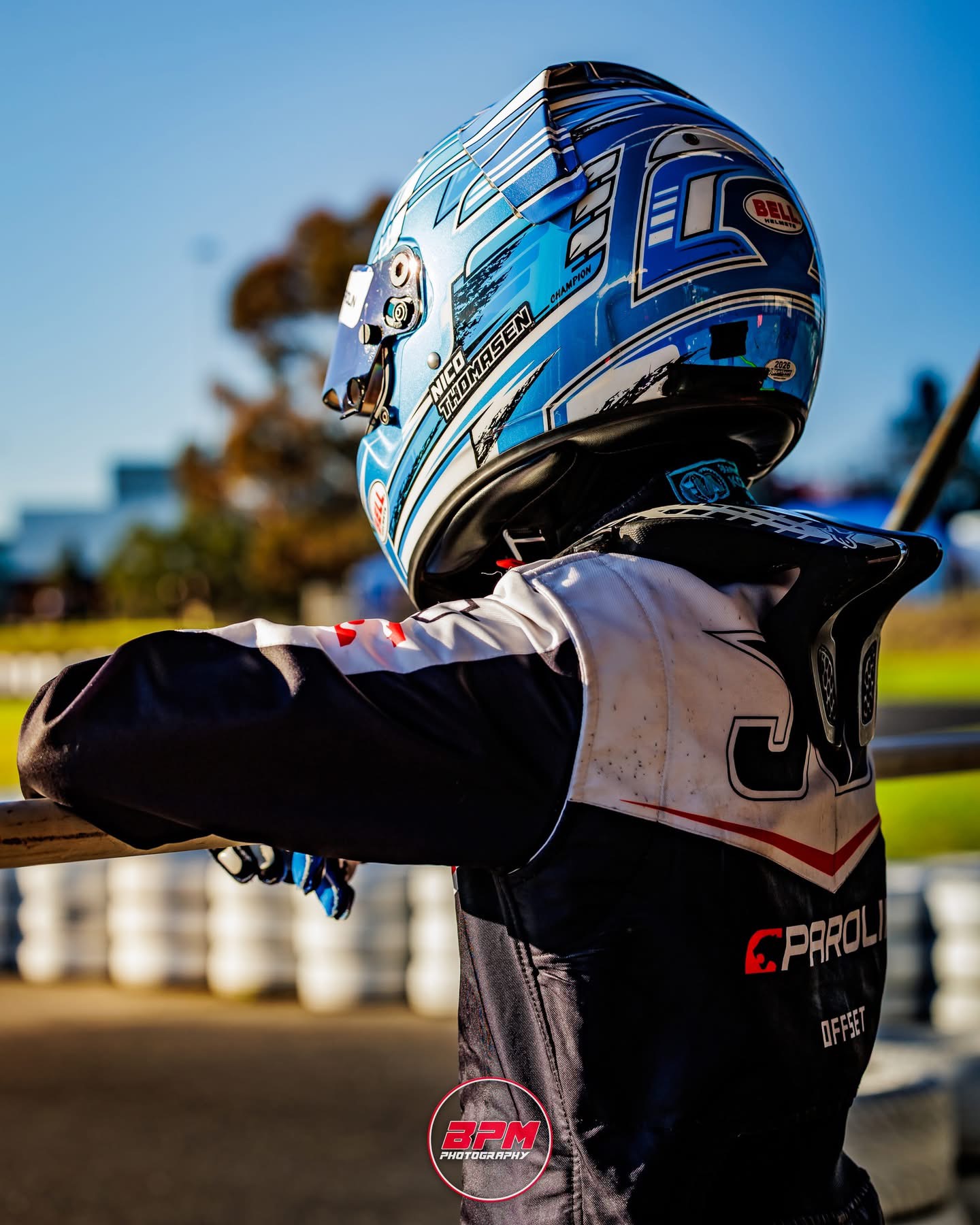 Nico Thomasen in his blue Bell helmet leaning on the trackside rail
