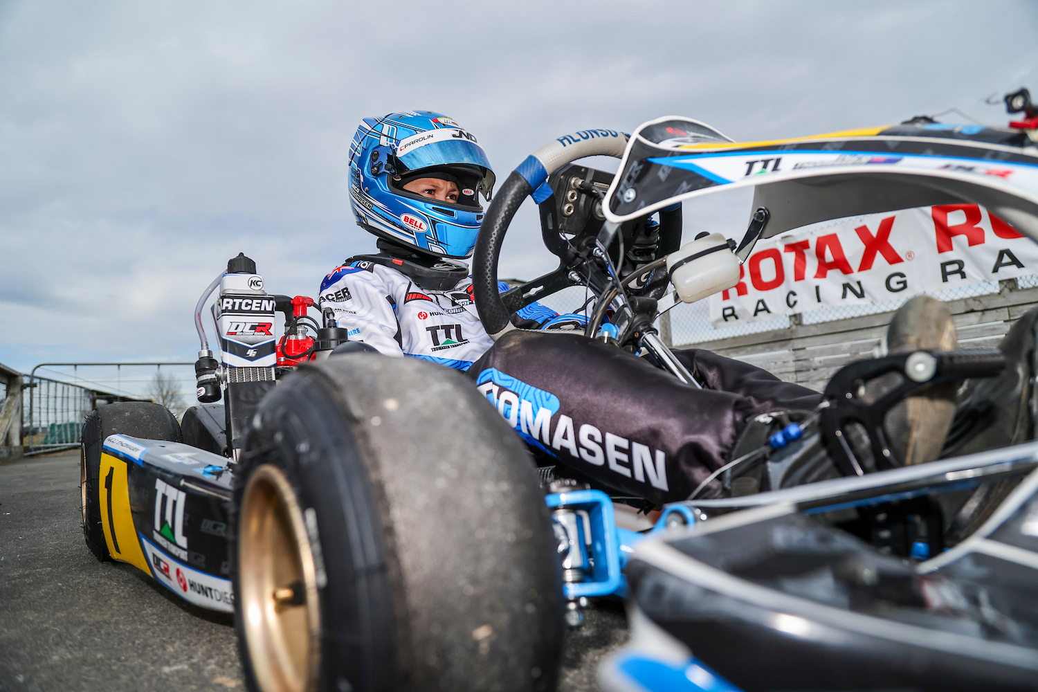 Nico Thomasen sitting in his kart on the grid beside a Rotax Racing banner